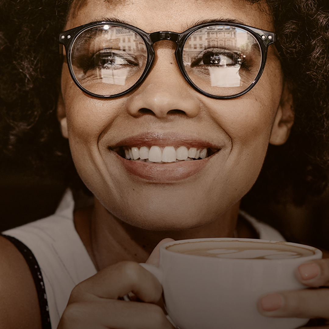 Mulher tomando café e sorrindo